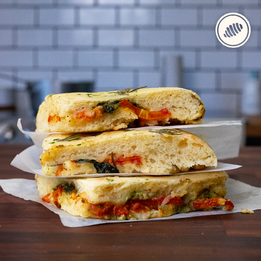 Farcita caprese; pan focaccia relleno de queso mozzarella, pesto de albahaca y tomates frescos. Para Hornear en casa. Pack individual. Hecho a mano, con huevos lácteos y harina de trigo (unbleached y libre de bromato).  Servicio delivery Area Metro: San Juan, Guaynabo, Carolina, Bayamón, Trujillo Alto, Toa Baja, Toa Alta, Dorado.  Club de Pasta - Della Rocca